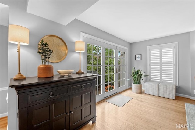 doorway with light wood-style floors and baseboards