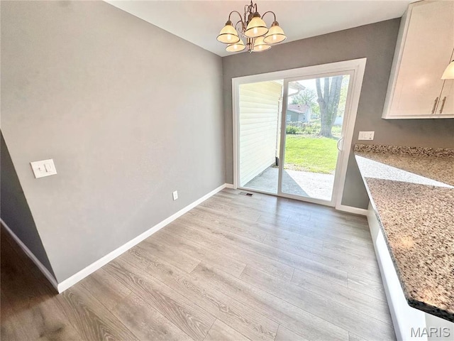 2944 Advance Dr, Florissant, MO 63031 - unfurnished dining area with baseboards, a chandelier, and light wood-type flooring
