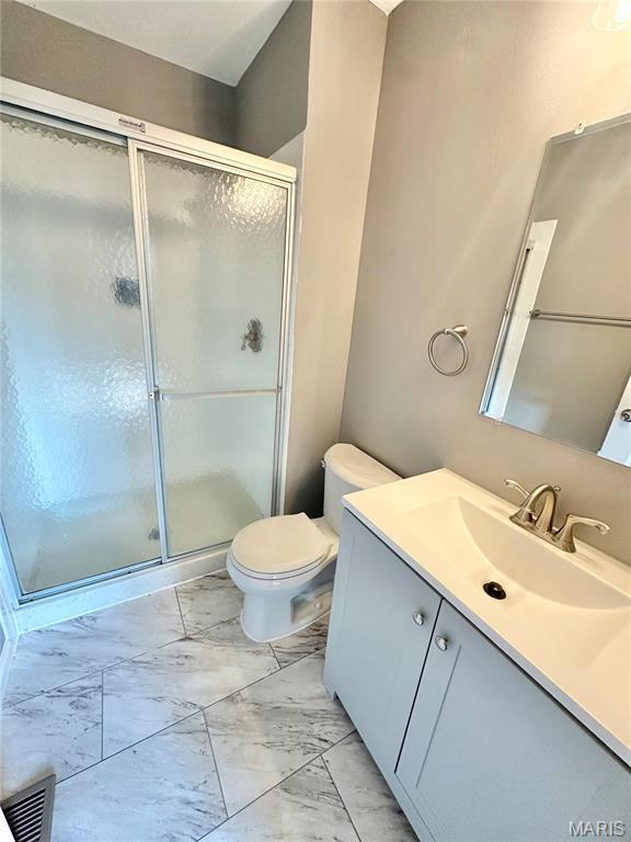 2944 Advance Dr, Florissant, MO 63031 - bathroom with marble finish floors, vanity, a stall shower, and toilet