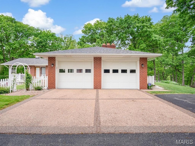 garage featuring driveway and fence