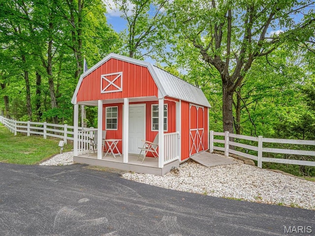 view of outbuilding with fence and an outdoor structure