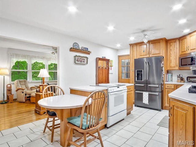 kitchen featuring appliances with stainless steel finishes, a ceiling fan, light countertops, and recessed lighting