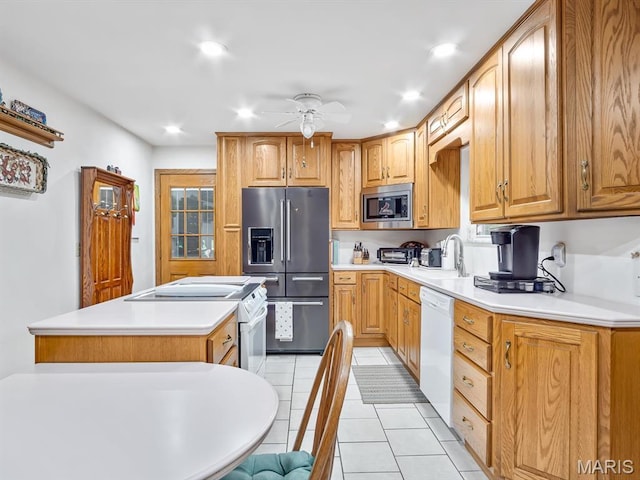 kitchen with appliances with stainless steel finishes, light tile patterned flooring, a sink, a ceiling fan, and light countertops