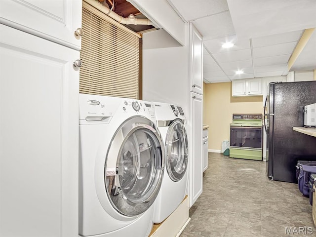 clothes washing area with washing machine and clothes dryer and baseboards