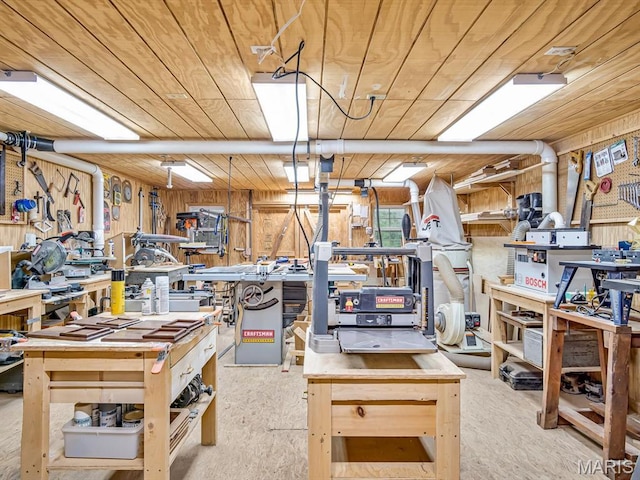 basement featuring a workshop area, wood ceiling, and wooden walls