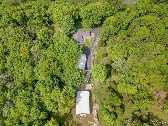 aerial view of property and surrounding area featuring a heavily wooded area