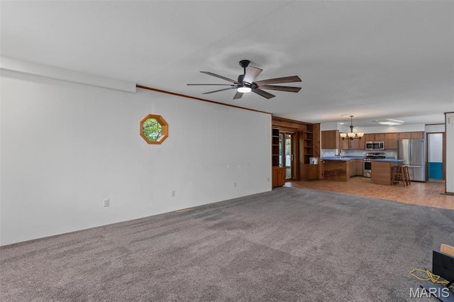 418 E Maple St, Gillespie, IL 62033 - unfurnished living room featuring a chandelier, a ceiling fan, light carpet, and plenty of natural light