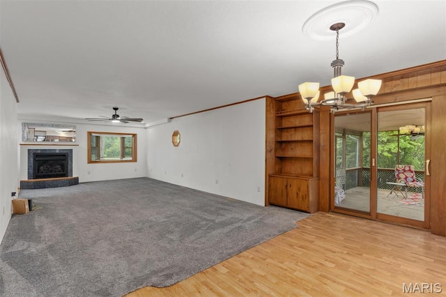 418 E Maple St, Gillespie, IL 62033 - unfurnished living room with a chandelier, a ceiling fan, wood finished floors, a premium fireplace, and crown molding