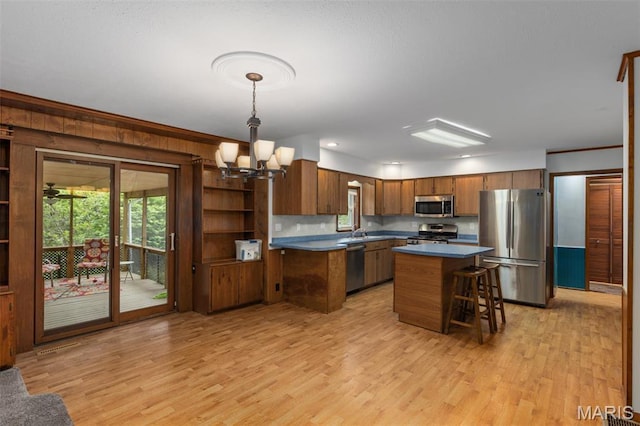 418 E Maple St, Gillespie, IL 62033 - kitchen featuring stainless steel appliances, brown cabinetry, light wood-style floors, a chandelier, and a sink