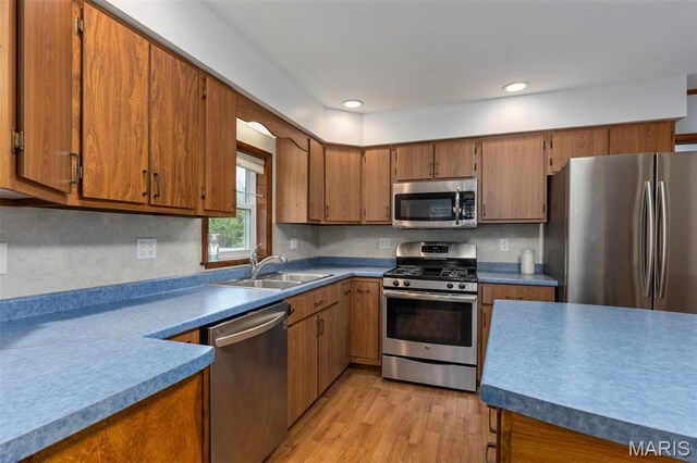 418 E Maple St, Gillespie, IL 62033 - kitchen with stainless steel appliances, a sink, brown cabinetry, light wood finished floors, and decorative backsplash