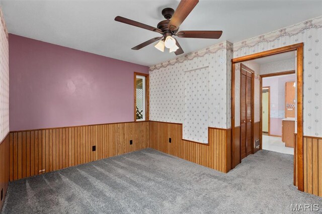 418 E Maple St, Gillespie, IL 62033 - spare room with a wainscoted wall, a ceiling fan, carpet, wallpapered walls, and wooden walls