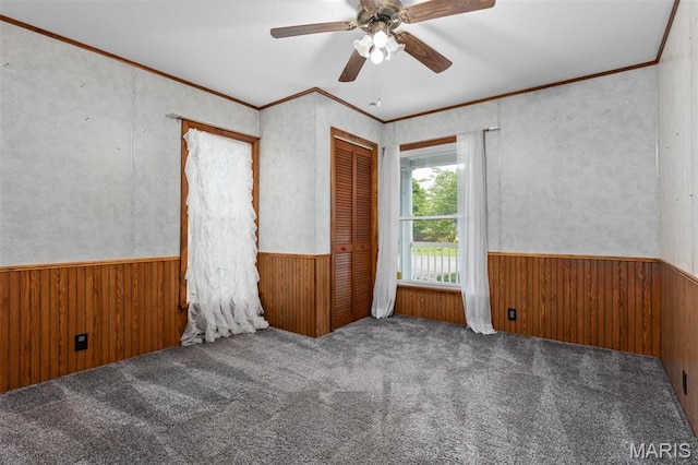 418 E Maple St, Gillespie, IL 62033 - carpeted empty room with a wainscoted wall, wooden walls, a ceiling fan, and crown molding