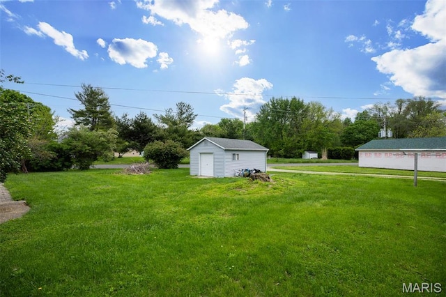 418 E Maple St, Gillespie, IL 62033 - view of green lawn with a garage, an outbuilding, a storage unit, and view of wooded area