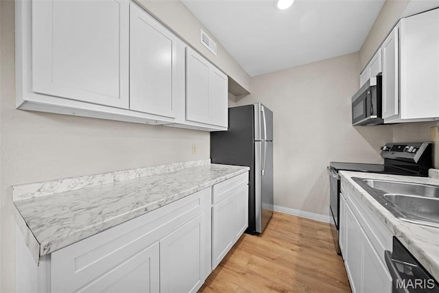 2104 Gascony Dr Unit 2104, Lake St Louis, MO 63367 - kitchen featuring stainless steel appliances, white cabinetry, light wood-style flooring, and baseboards