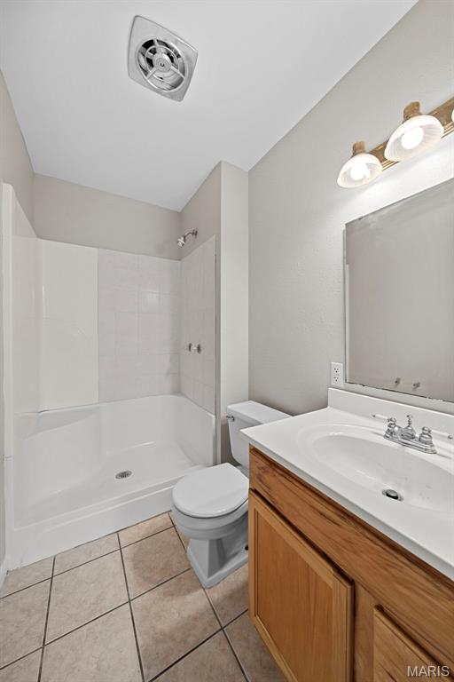2104 Gascony Dr Unit 2104, Lake St Louis, MO 63367 - bathroom featuring tile patterned flooring, a shower, toilet, and vanity