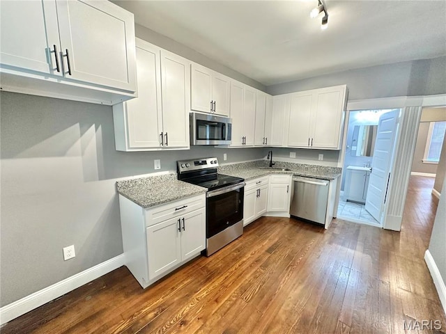 2806 Keokuk St, Saint Louis, MO 63118 - kitchen with appliances with stainless steel finishes, a sink, dark wood finished floors, and baseboards