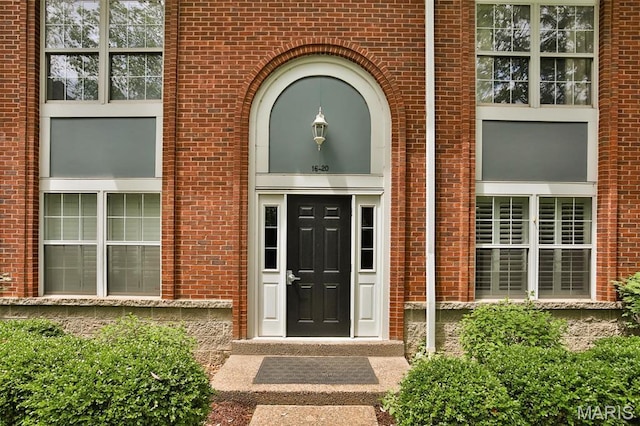 doorway to property featuring brick siding
