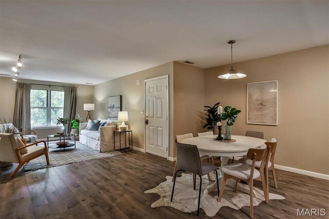 dining space with dark wood finished floors and baseboards