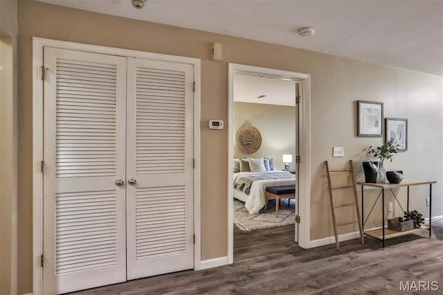 hallway with dark wood-type flooring and baseboards