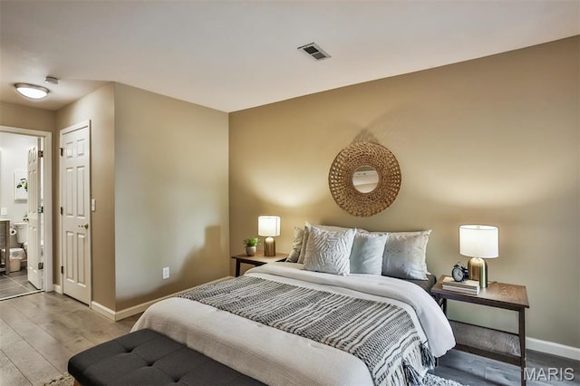 bedroom featuring wood finished floors and baseboards