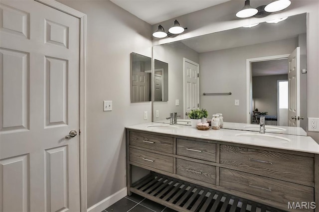bathroom with tile patterned flooring, double vanity, and baseboards