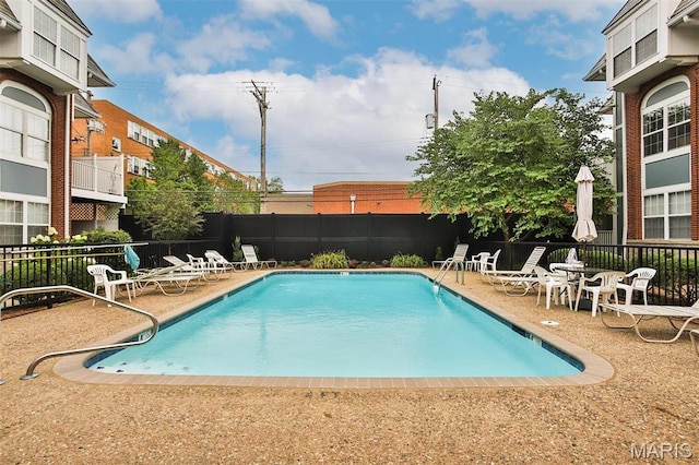 community pool with fence and a patio area