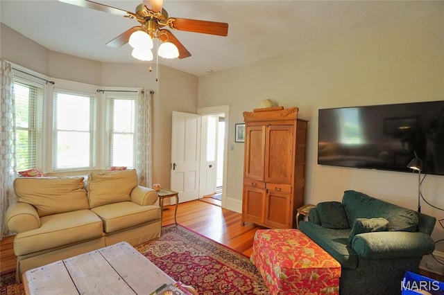 living room with light wood finished floors and a ceiling fan