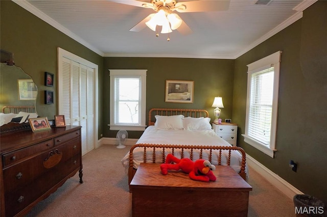 bedroom featuring light carpet, baseboards, ornamental molding, a closet, and ceiling fan