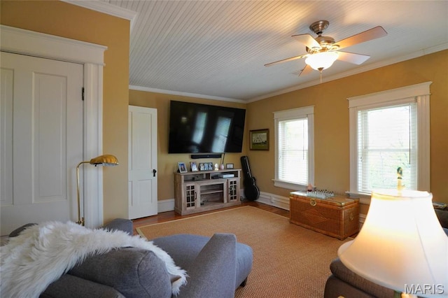 living room featuring ceiling fan, ornamental molding, baseboards, and wood finished floors