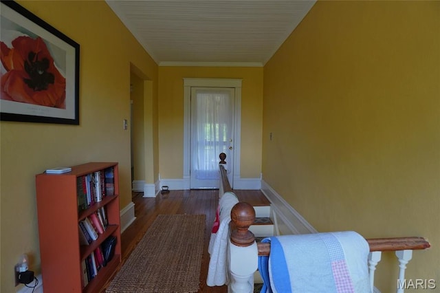 hallway featuring wood finished floors, baseboards, and ornamental molding