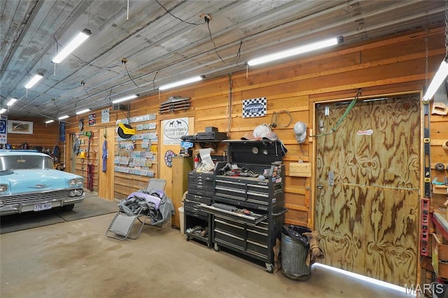 garage featuring wood walls and a workshop area