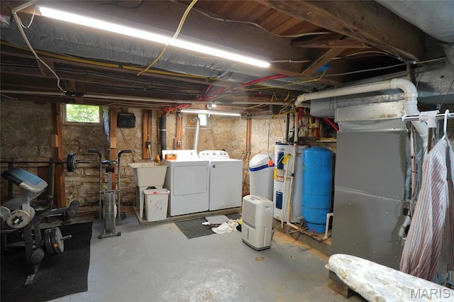 basement with independent washer and dryer, a water pressure tank, electric water heater, and a sink