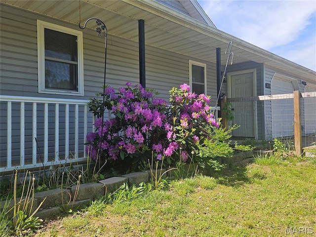 24355 Trolley Ln, Saint Robert, MO 65584 - view of side of home featuring a porch, a garage, and a lawn