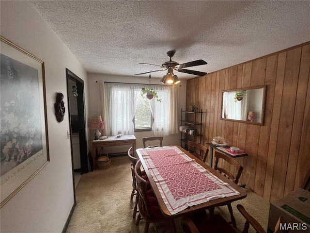 152 Burchwood Dr, St James, MO 65559 - dining space featuring light carpet, wooden walls, ceiling fan, and a textured ceiling