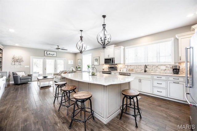 9 Shellie Ct, Fairview Heights, IL 62208 - kitchen featuring appliances with stainless steel finishes, open floor plan, a sink, a kitchen breakfast bar, and white cabinets