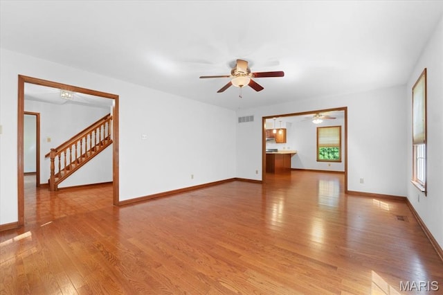 3743 Rock Creek Valley Rd, High Ridge, MO 63049 - unfurnished room with light wood finished floors, a ceiling fan, stairs, and baseboards