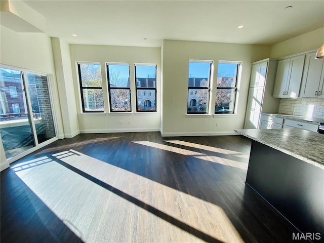 4301 Maryland Ave Unit 2, Saint Louis, MO 63108 - unfurnished living room featuring dark wood-type flooring, baseboards, and recessed lighting