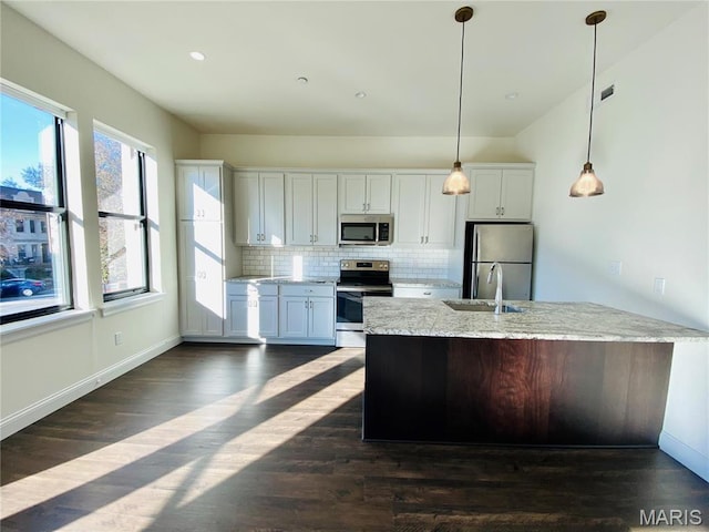 4301 Maryland Ave Unit 2, Saint Louis, MO 63108 - kitchen with appliances with stainless steel finishes, backsplash, dark wood-style floors, decorative light fixtures, and white cabinets