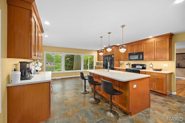350 Barnett Dr, Edwardsville, IL 62025 - kitchen with black appliances, baseboards, stone finish floors, brown cabinets, and recessed lighting