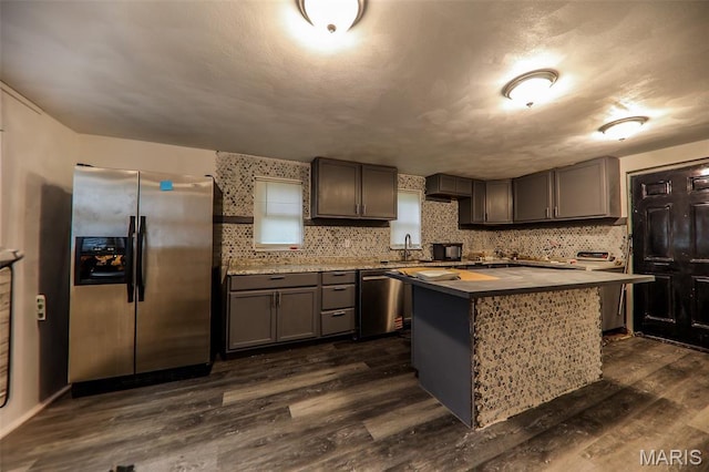 226 N 8th St, Belleville, IL 62220 - kitchen featuring stainless steel appliances, dark wood-type flooring, a kitchen island, light countertops, and tasteful backsplash