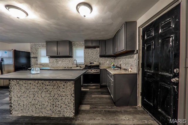 226 N 8th St, Belleville, IL 62220 - kitchen featuring appliances with stainless steel finishes, a sink, gray cabinets, dark wood-style floors, and a kitchen island