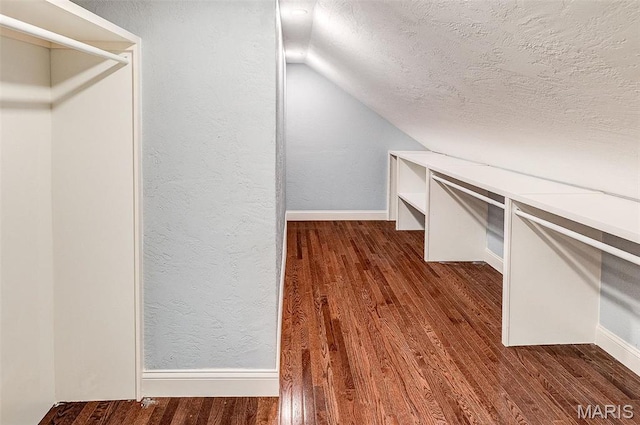 walk in closet featuring dark wood finished floors and vaulted ceiling