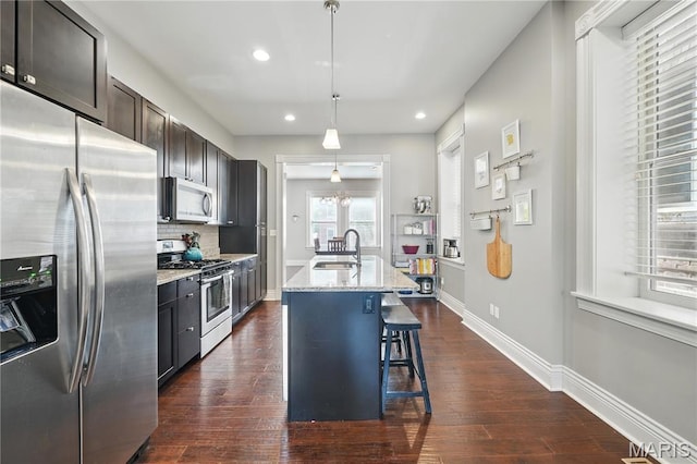 3015 Indiana Ave, Saint Louis, MO 63118 - kitchen with appliances with stainless steel finishes, a sink, a kitchen breakfast bar, recessed lighting, and light stone counters