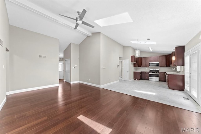 2713 Chapel View Dr, Florissant, MO 63031 - unfurnished living room with lofted ceiling, ceiling fan, light wood-style floors, a skylight, and baseboards
