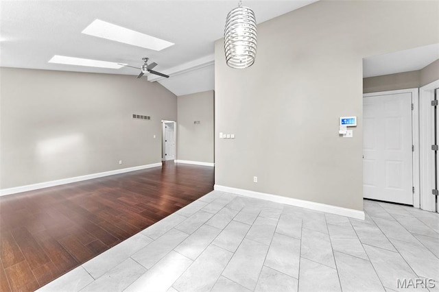 2713 Chapel View Dr, Florissant, MO 63031 - empty room featuring a skylight, lofted ceiling, light wood finished floors, a ceiling fan, and baseboards