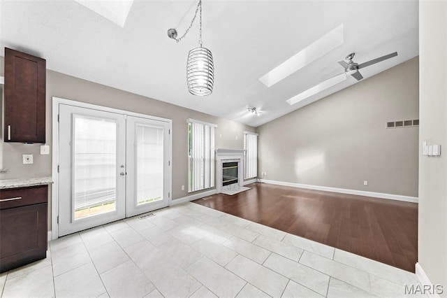 2713 Chapel View Dr, Florissant, MO 63031 - unfurnished living room with a skylight, lofted ceiling, a ceiling fan, french doors, and baseboards