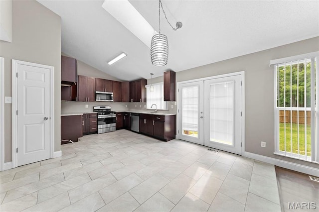 2713 Chapel View Dr, Florissant, MO 63031 - kitchen featuring stainless steel appliances, lofted ceiling, a sink, light countertops, and pendant lighting