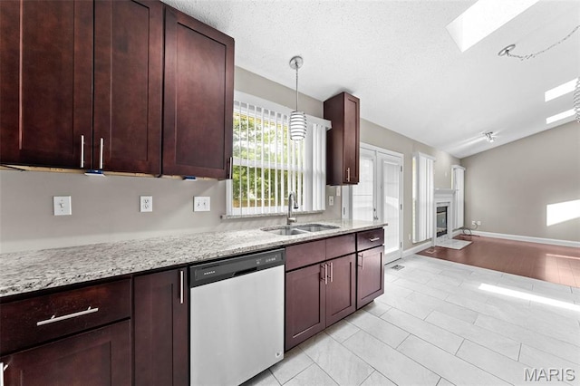 2713 Chapel View Dr, Florissant, MO 63031 - kitchen with stainless steel dishwasher, a sink, light stone countertops, a glass covered fireplace, and pendant lighting