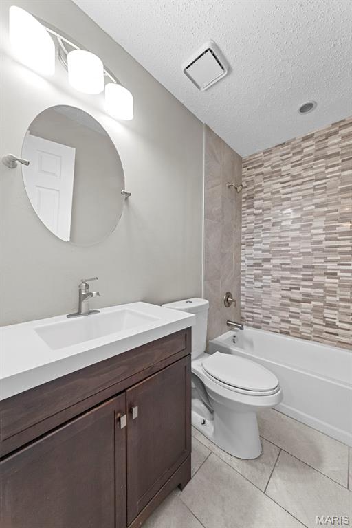 2713 Chapel View Dr, Florissant, MO 63031 - full bath featuring vanity, toilet, shower / bath combination, a textured ceiling, and tile patterned flooring