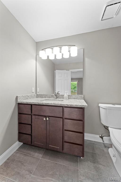 2713 Chapel View Dr, Florissant, MO 63031 - bathroom featuring toilet, baseboards, and vanity